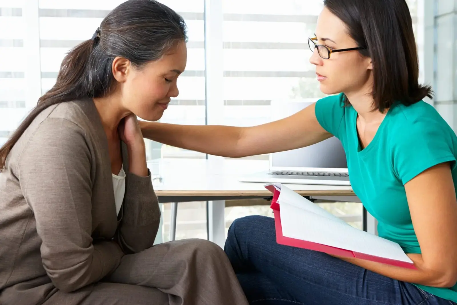 A counselor offering compassionate support to a woman in therapy