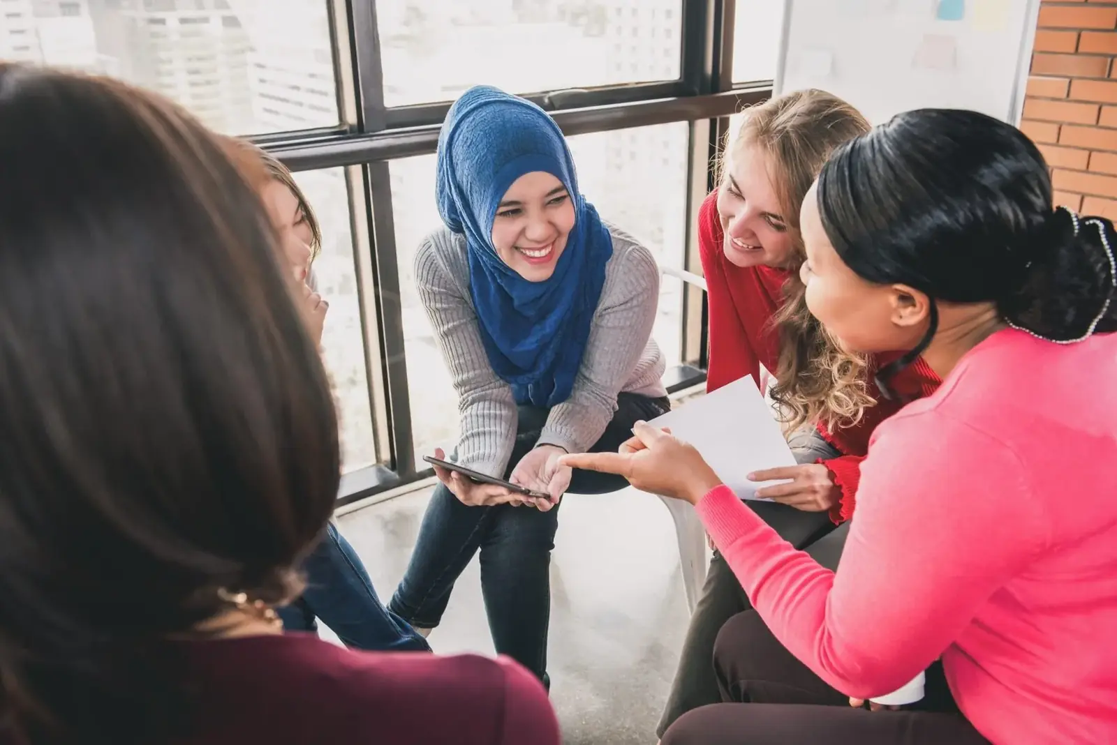 A diverse group of women sitting together in a supportive circle