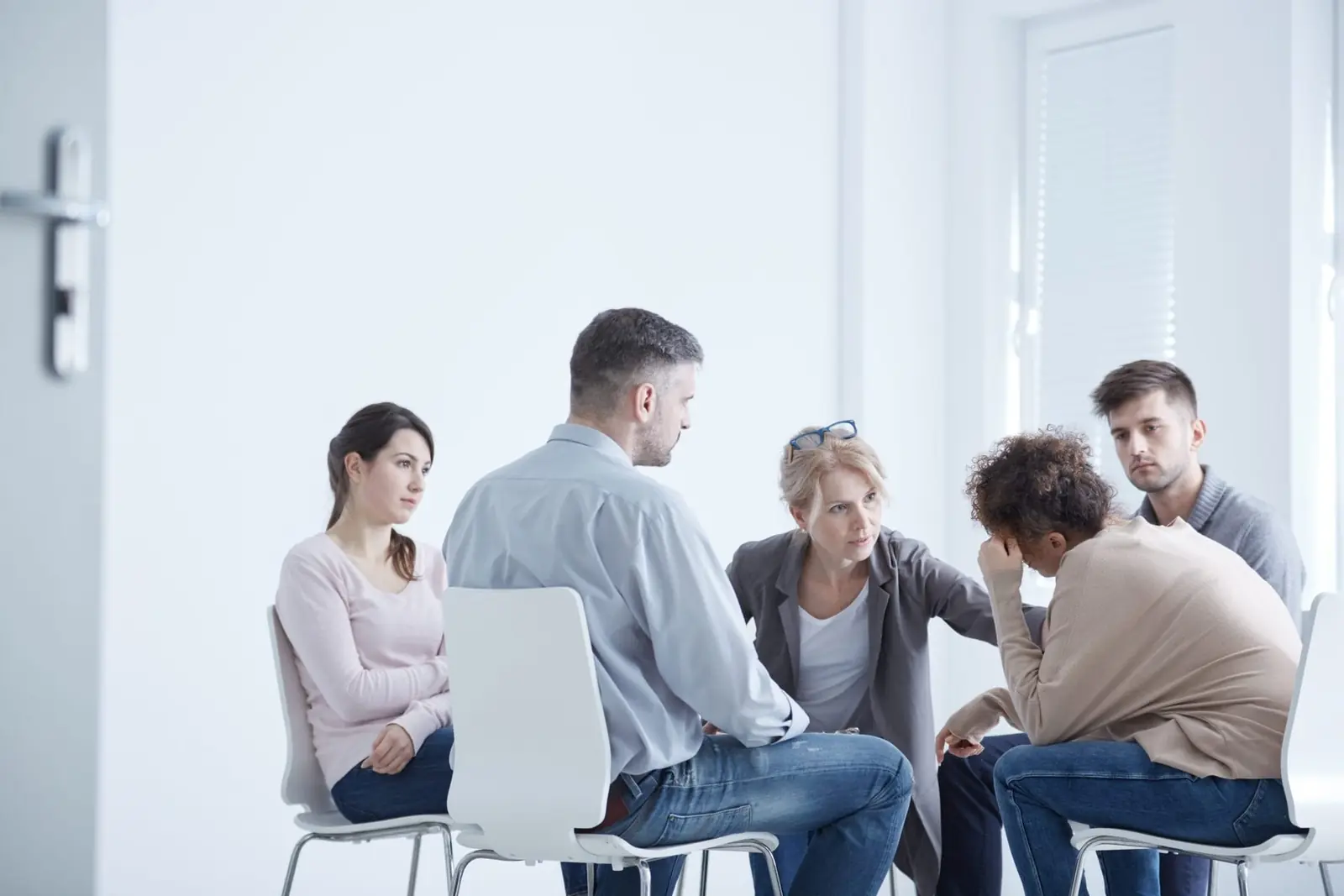 A women's-only group therapy circle, four women in conversation